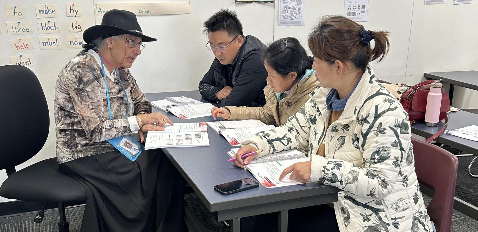 A teacher and adult learners studying English