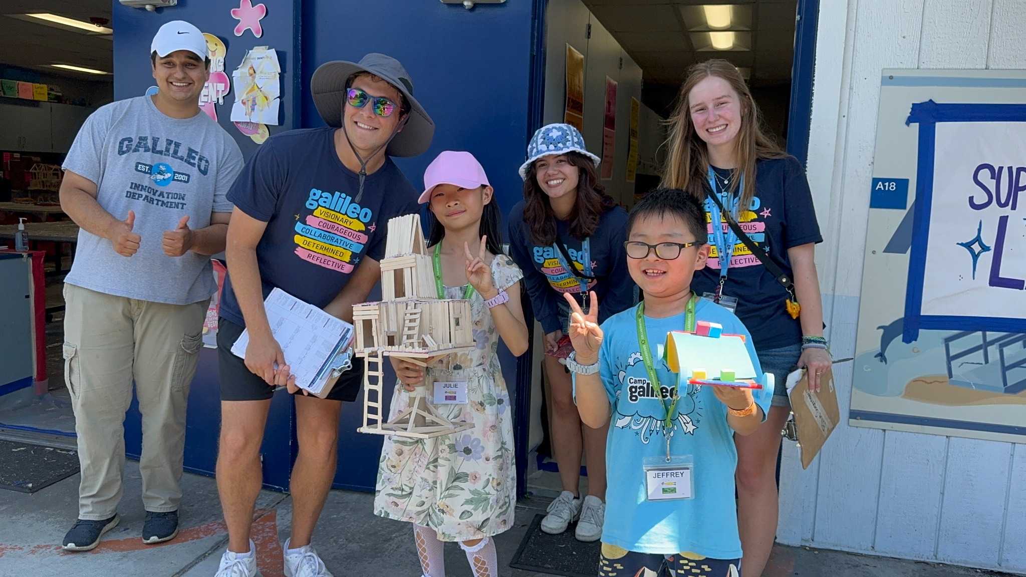Children showing their creations with camp companions