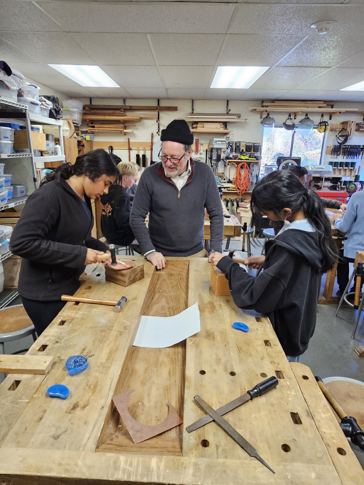 Teacher and students in a woodworking workshop