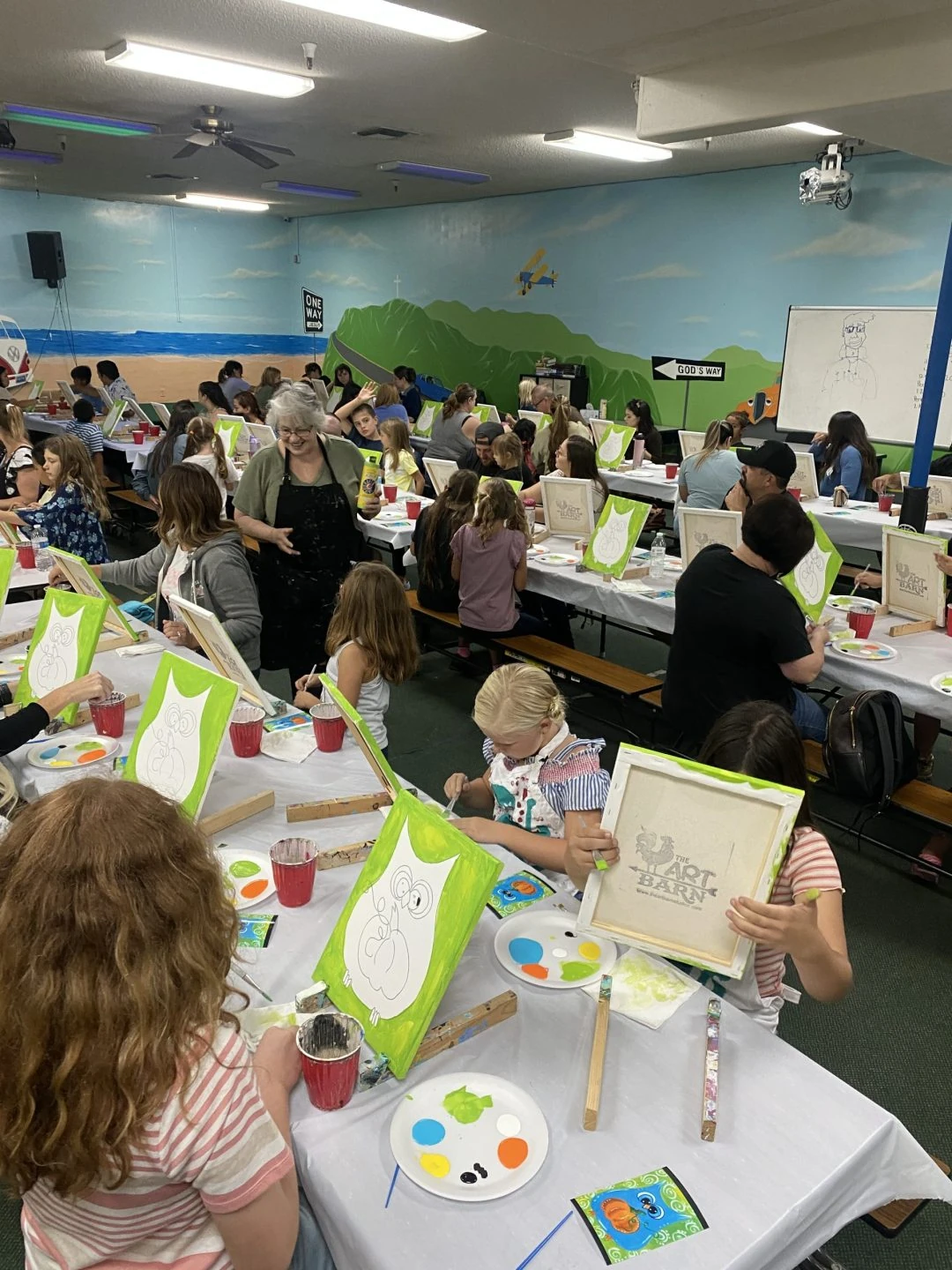 Students and adults taking part in a painting activity
