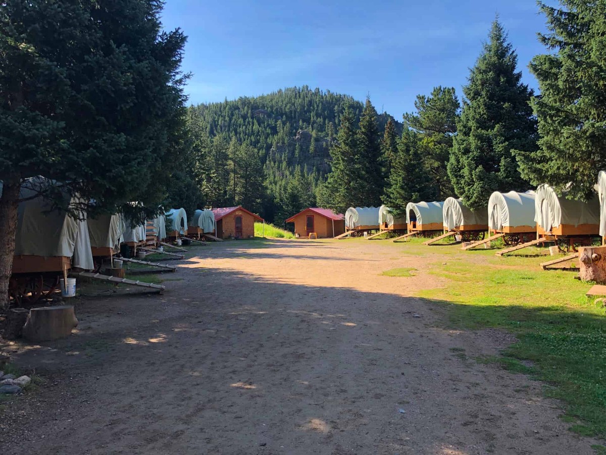 Cheley Family Camp: covered-wagon accommodation among the trees.