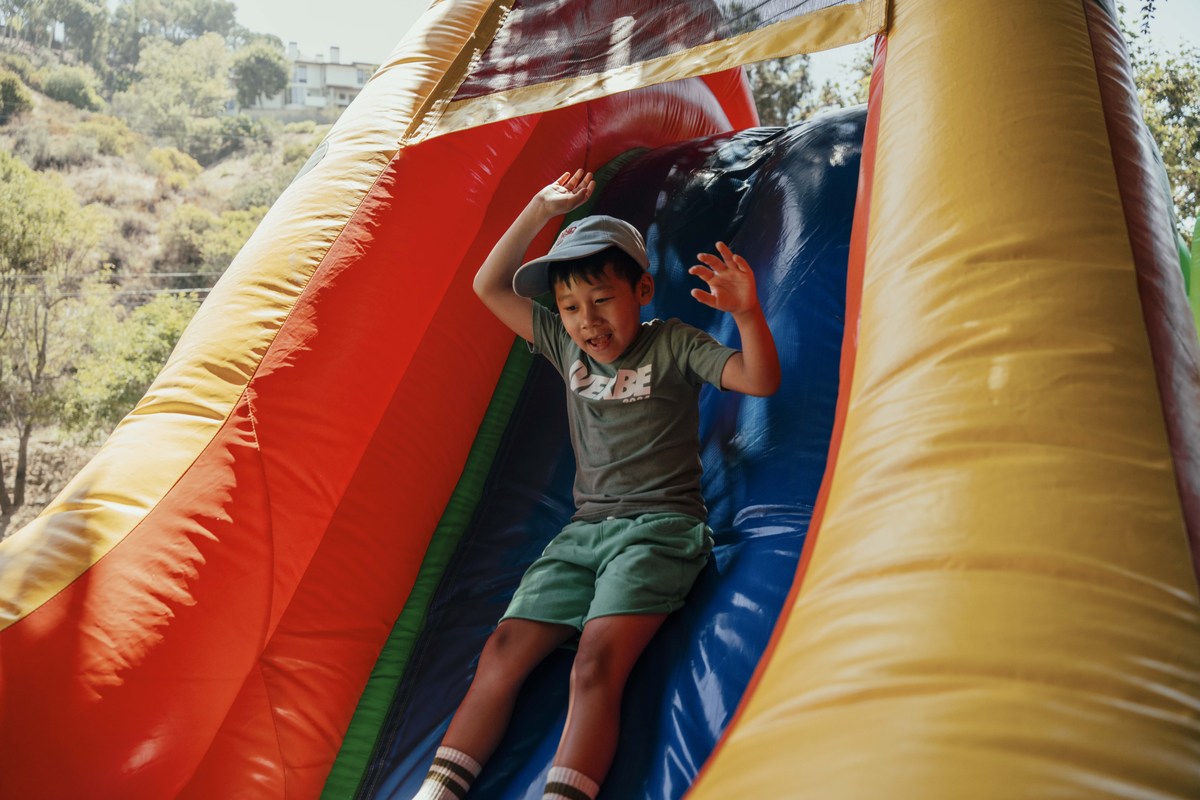 A camper slides down a colorful inflatable slide