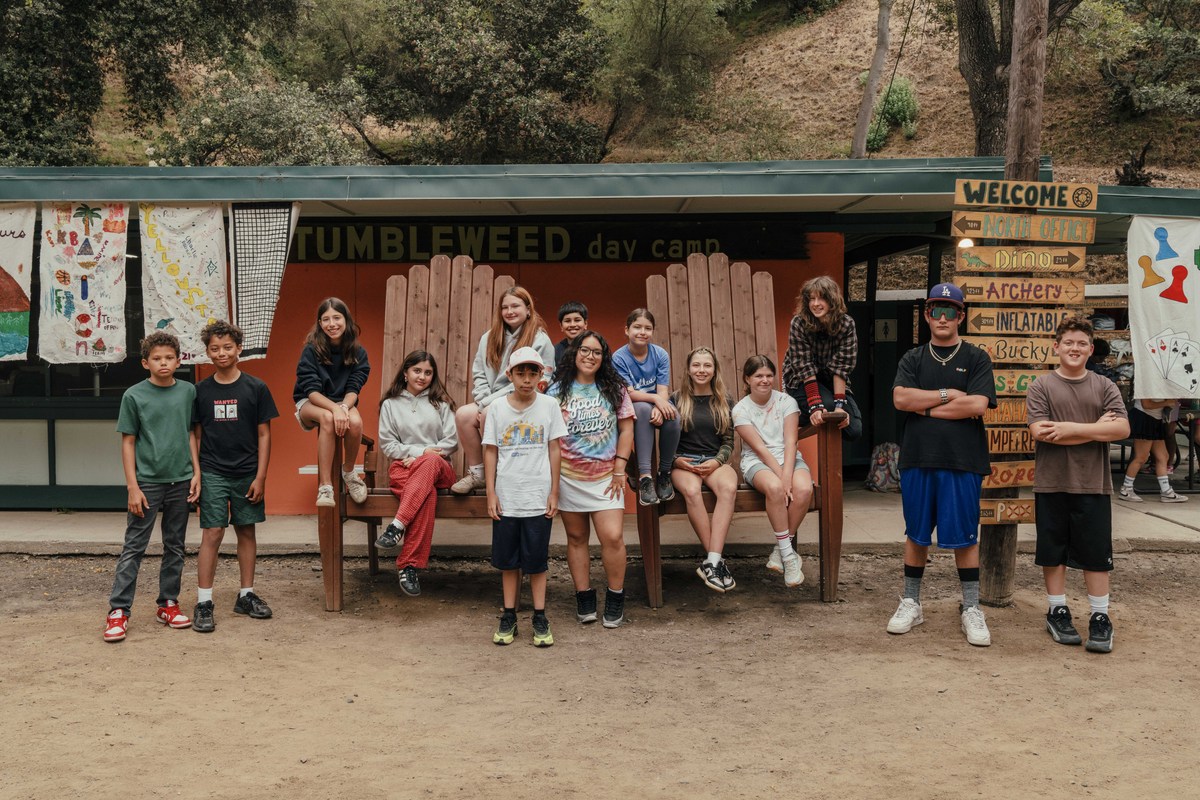 Campers and staff gather by the Tumbleweed camp sign