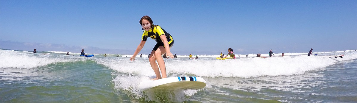 A past camper practises surfing near shore