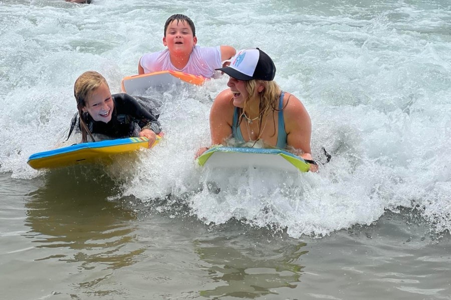 Campers try boogie boarding in the surf