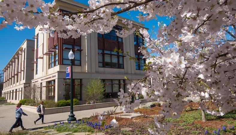An American University campus building and spring trees