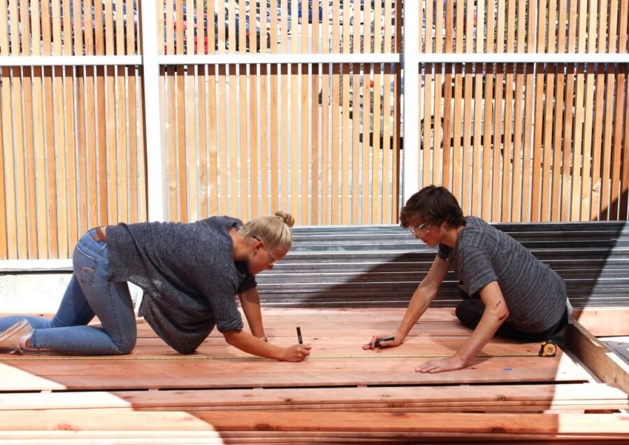 Students measuring timber during design/build work