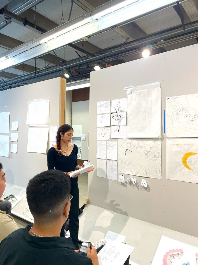 A student presenting design drawings for critique