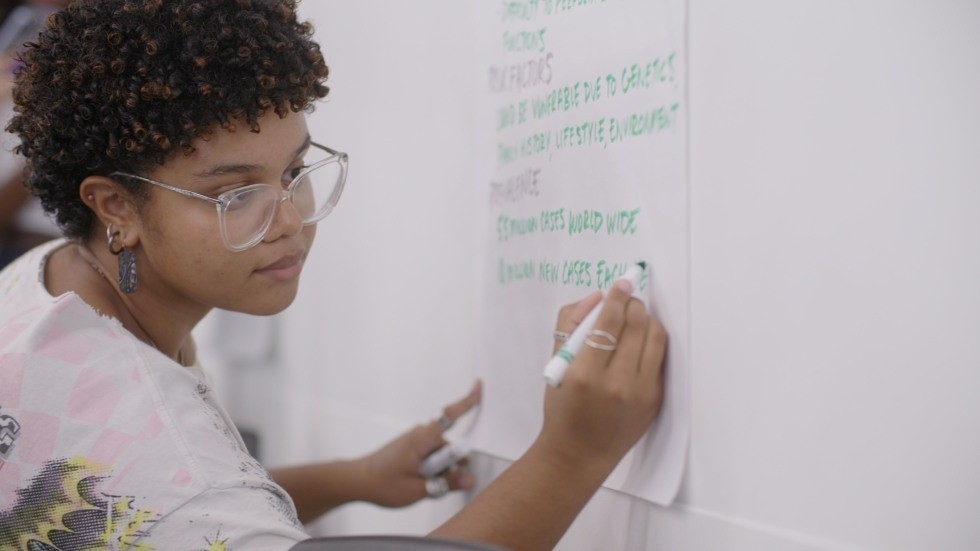 A student recording ideas on a whiteboard