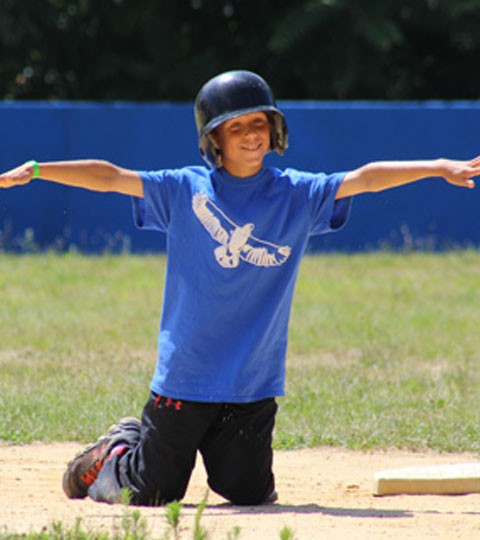 A helmeted camper on the baseball field