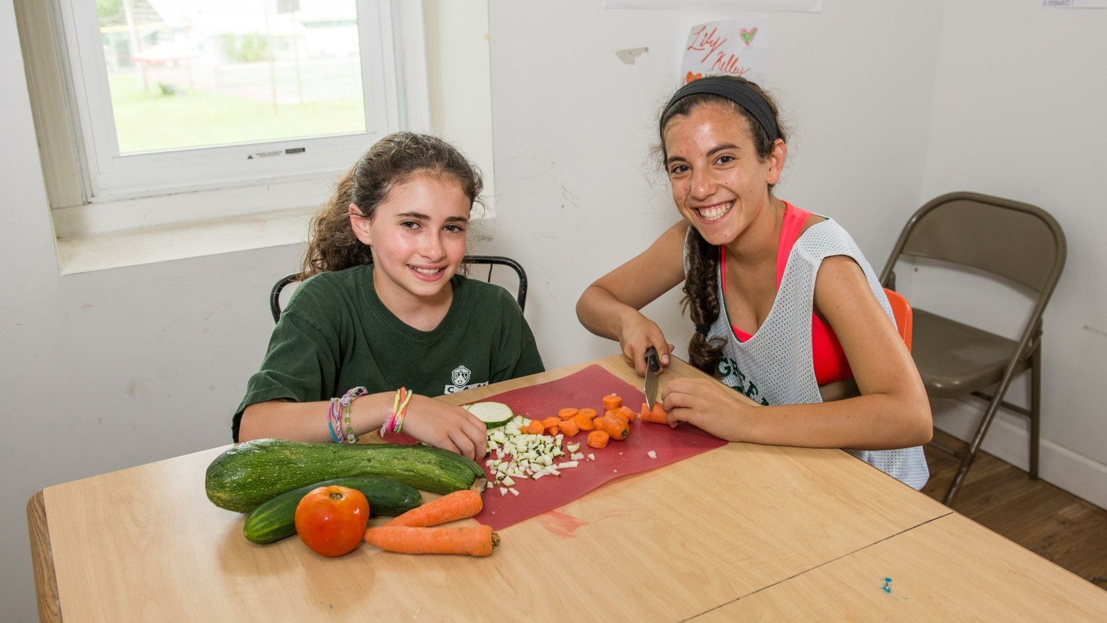 A camper and staff member preparing ingredients