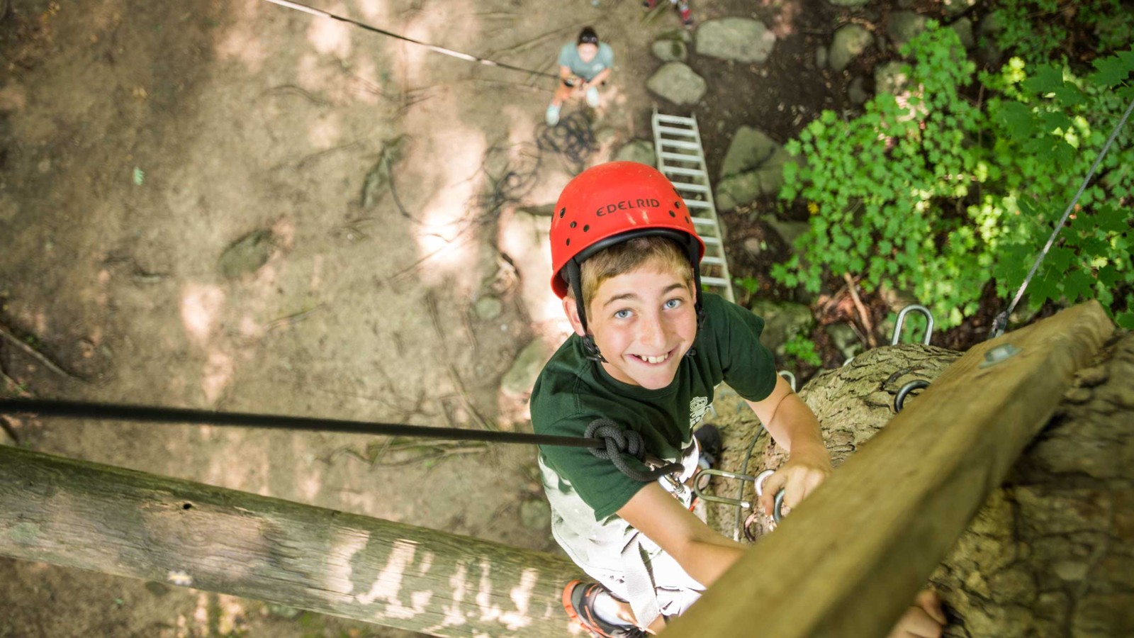 A helmeted camper climbing