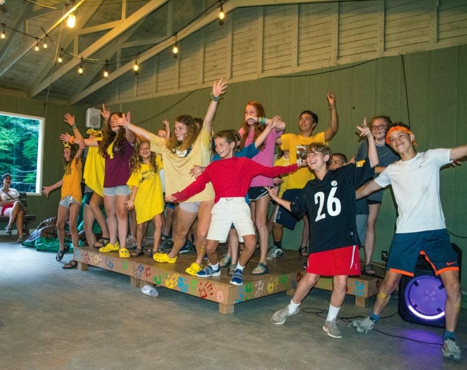 Campers perform on an indoor stage