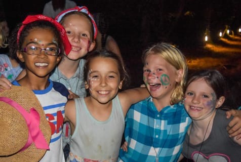 Campers with face paint gather for an evening photo
