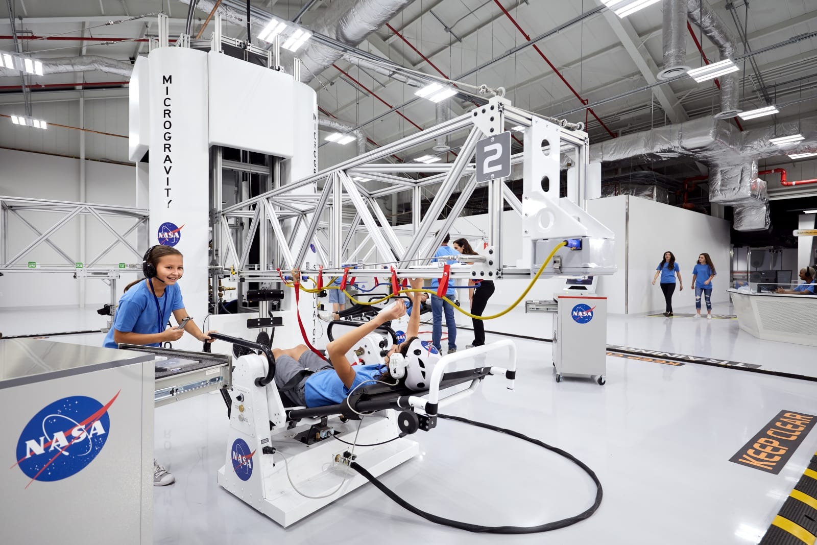A student using a microgravity simulator beside an instructor