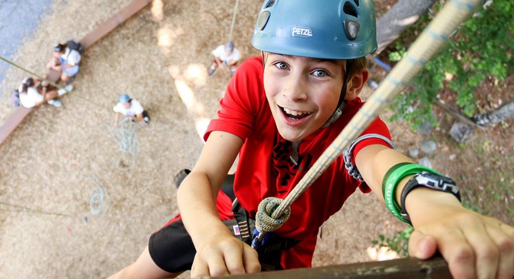 A camper taking part in a climbing activity