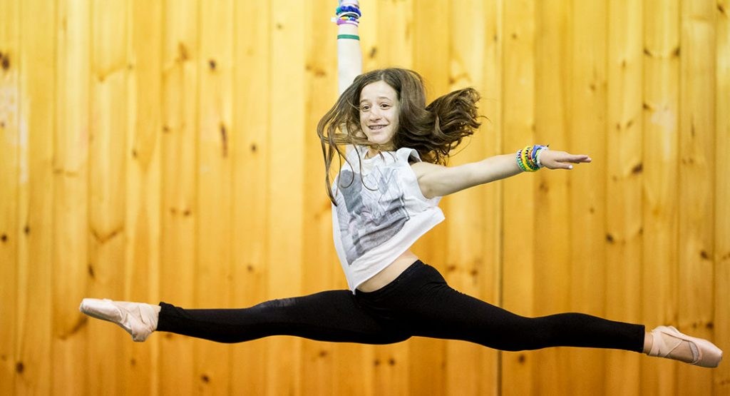 A camper practicing a dance leap