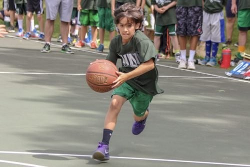 A camper dribbles a basketball on the court