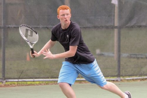 A camper prepares to hit a tennis ball
