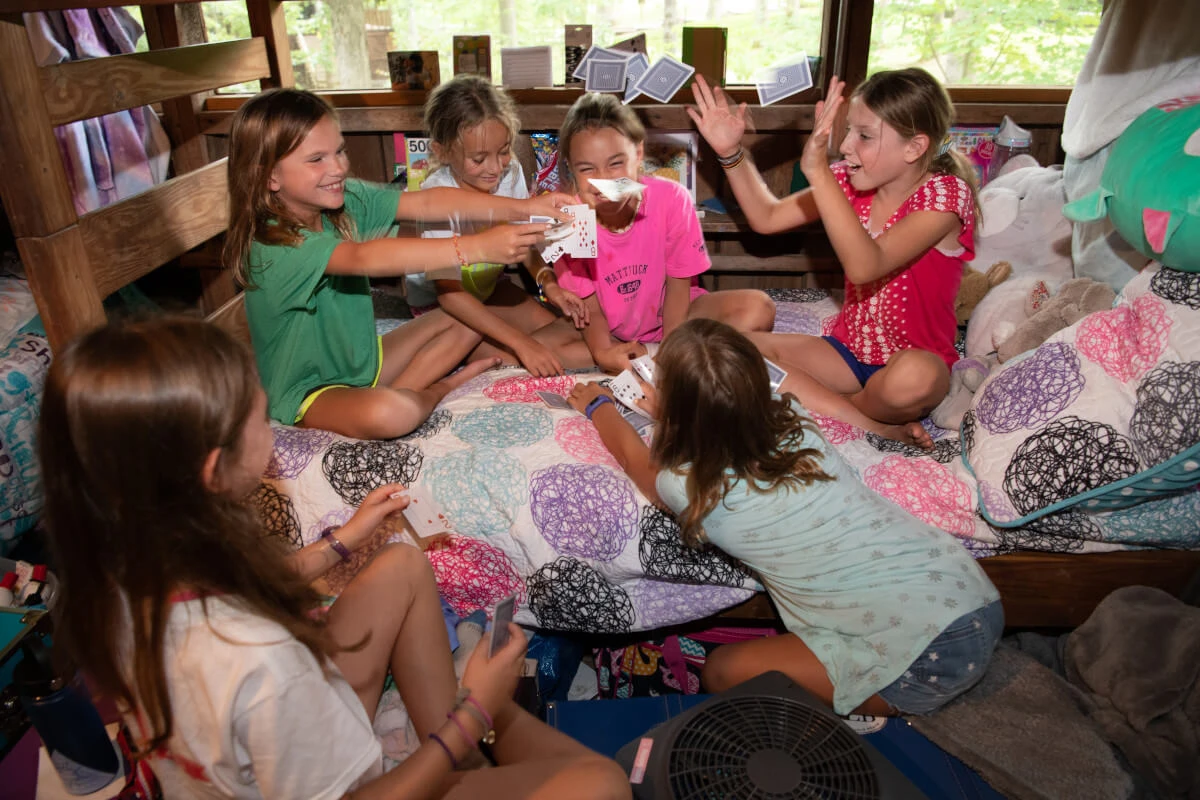 Campers play cards together in a cabin