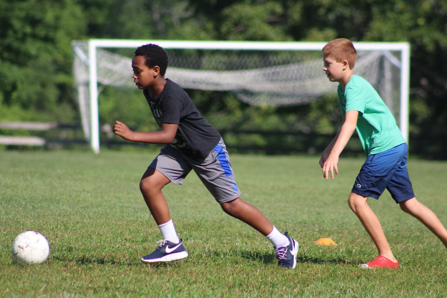 Campers playing soccer on a grass field