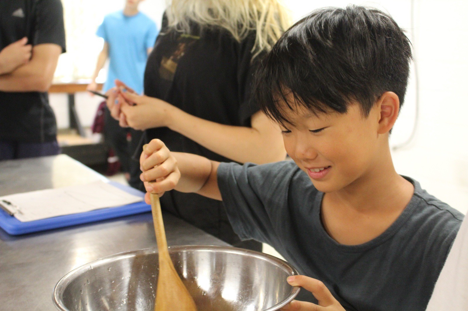 A camper mixing ingredients during a cooking activity
