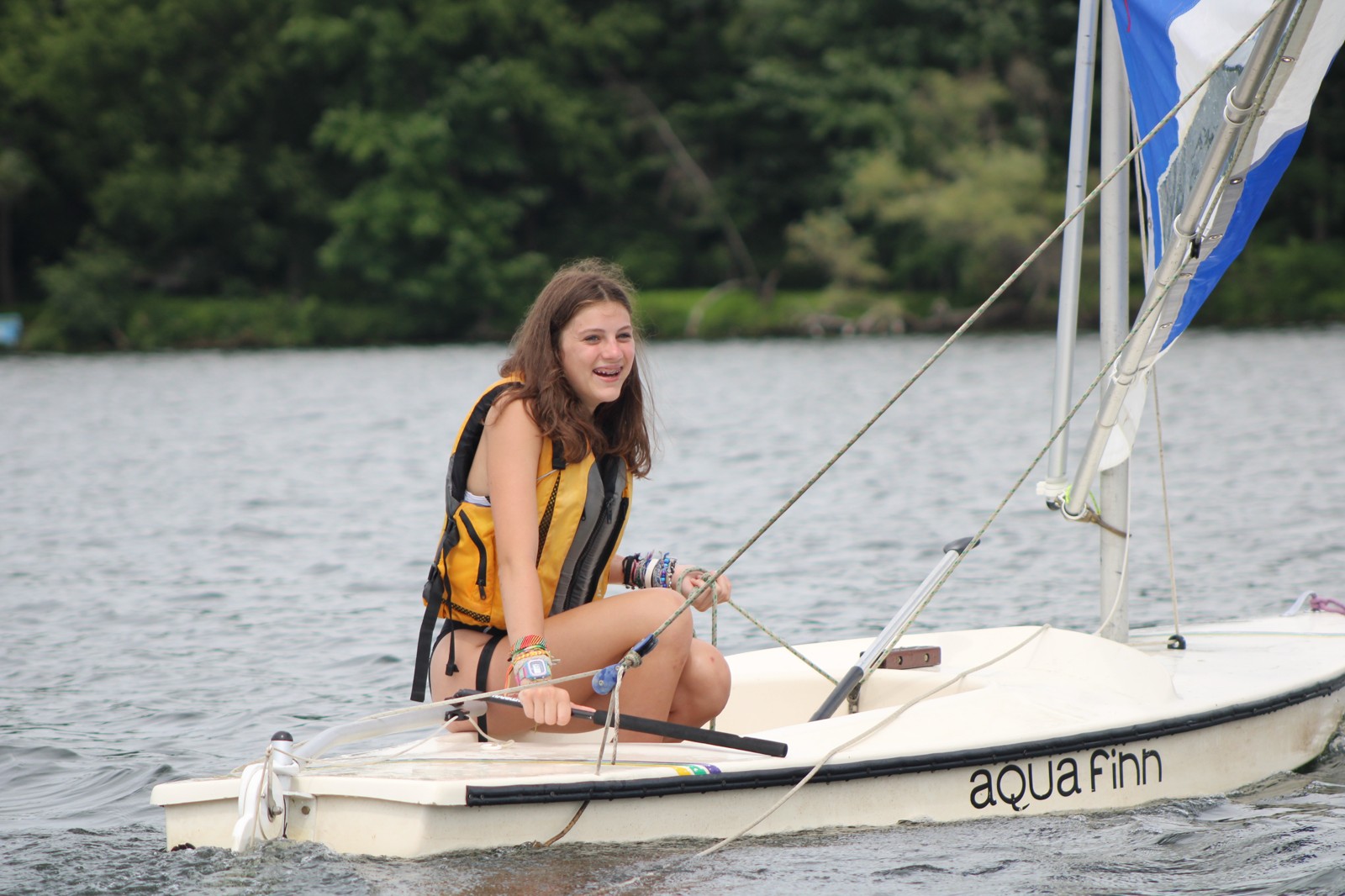 A camper learning to sail on the lake
