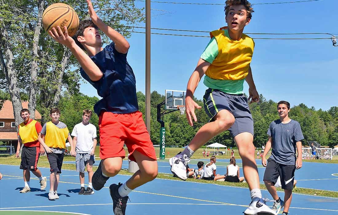 Campers playing basketball on an outdoor court