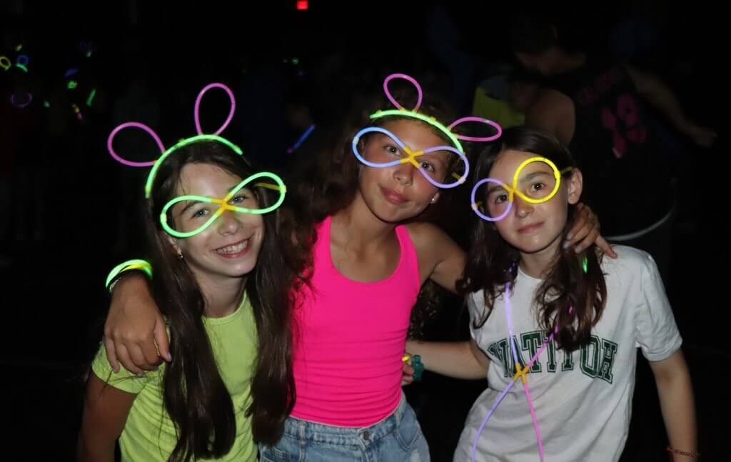 Campers wearing glow accessories at an evening activity