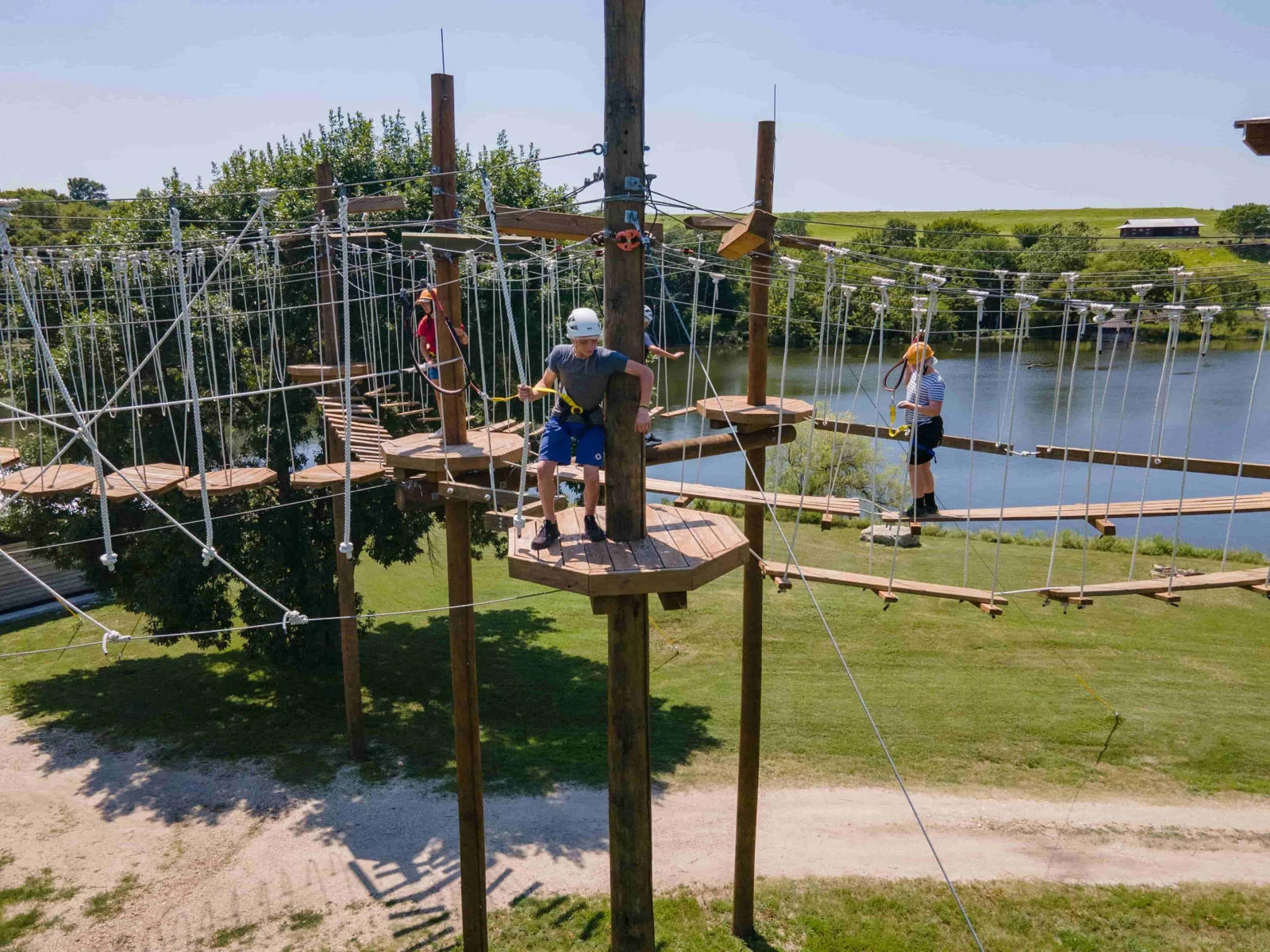 Campers use the high-ropes course beside the lake