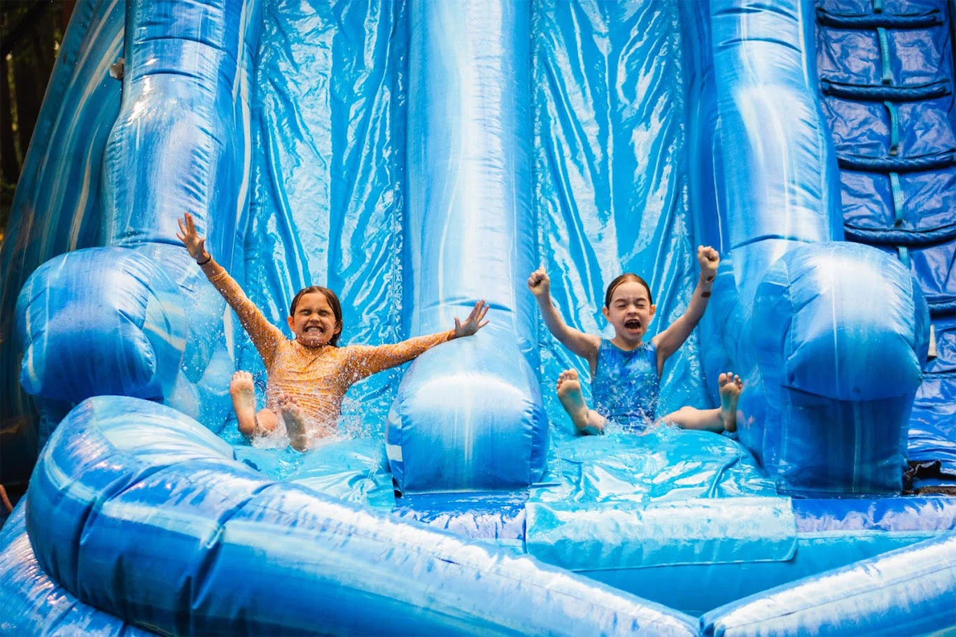Campers slide down an inflatable waterslide