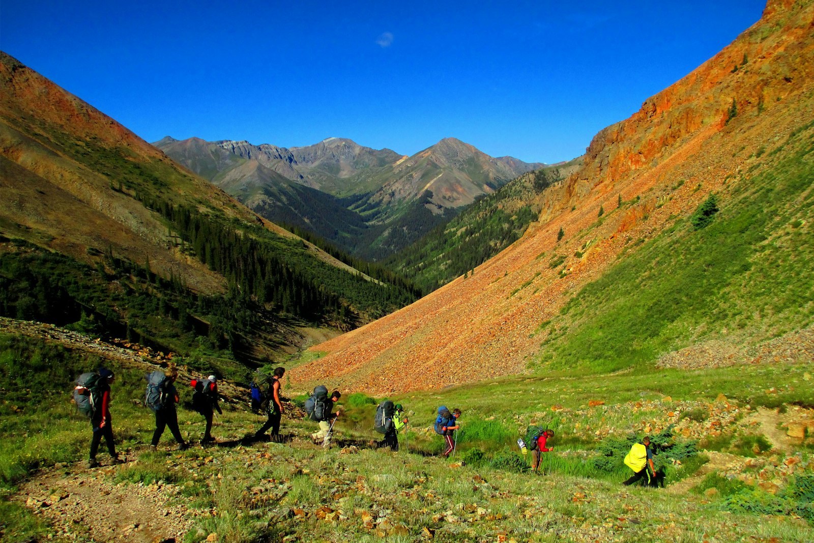 A group hikes through a mountain valley