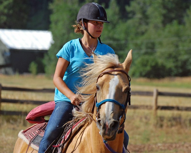A helmeted camper takes part in riding