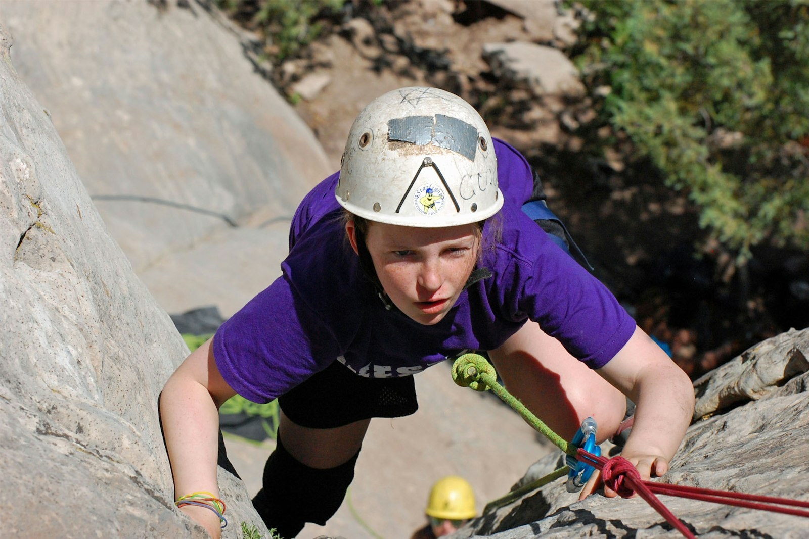 A camper rock-climbs with a rope system