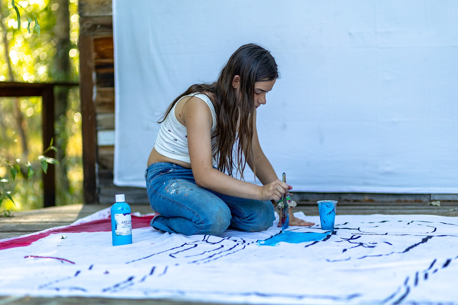 A camper works on an outdoor painting project