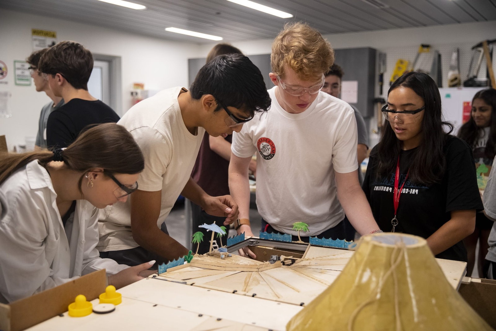Students examining an engineering device and model together