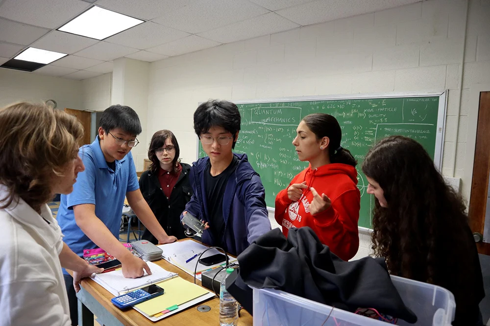Students discuss and demonstrate a laboratory setup