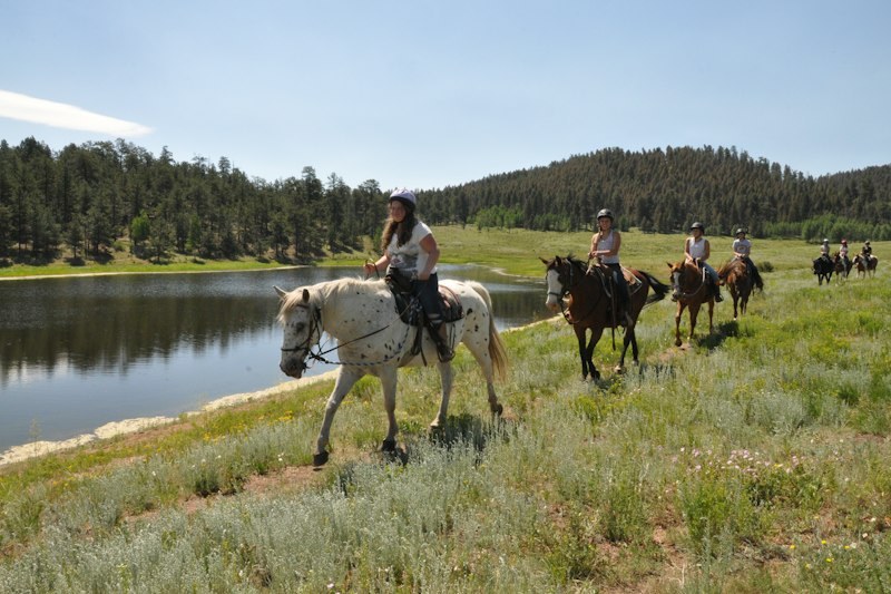 Campers ride through lakeside meadow