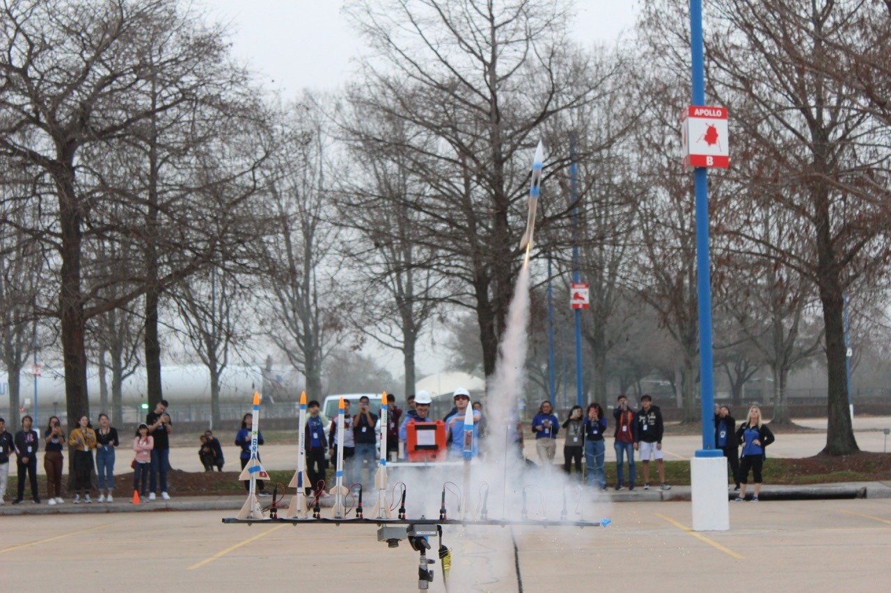Students watching an outdoor model-rocket launch