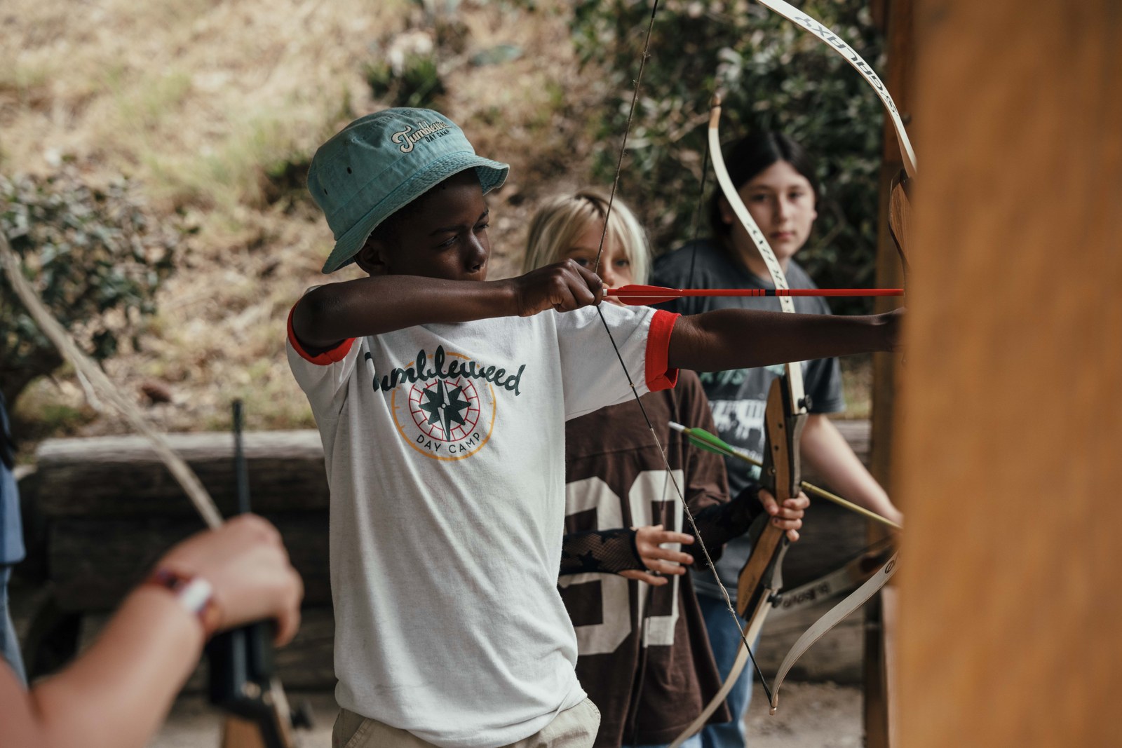 Campers practise archery with staff guidance