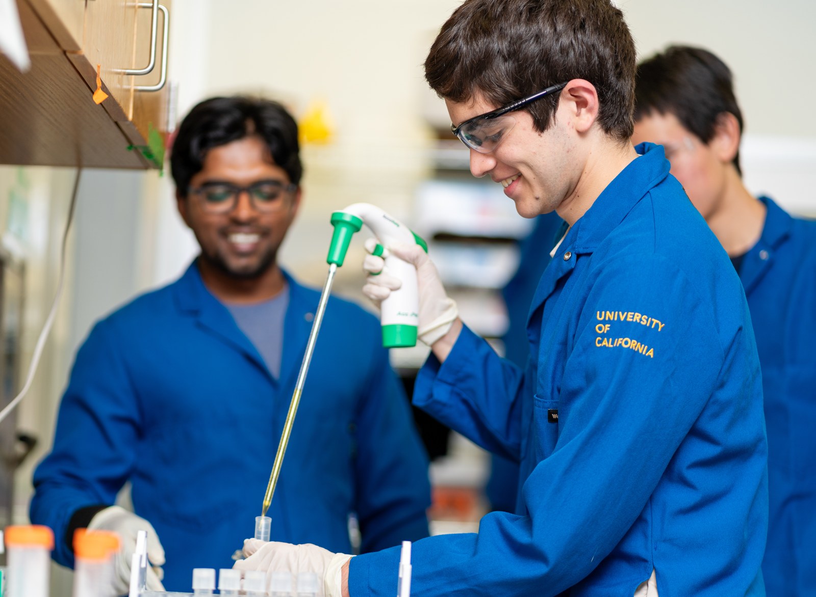 Research students using a pipette in a laboratory