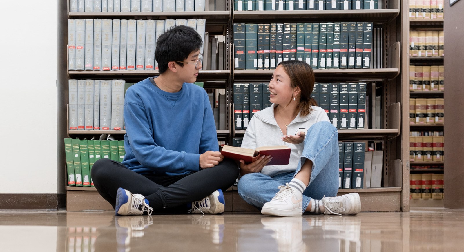 Students discussing reading in the library