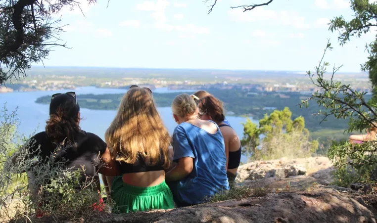 Campers look across the lake from a rocky overlook