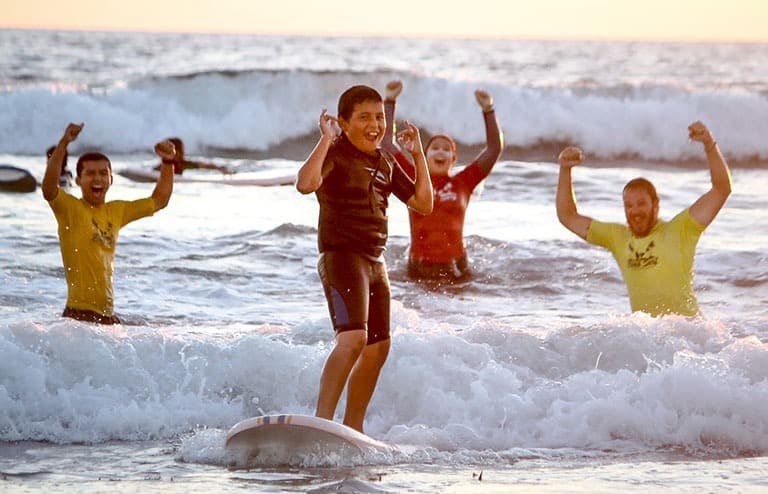 Past campers and staff take part in a surfing activity