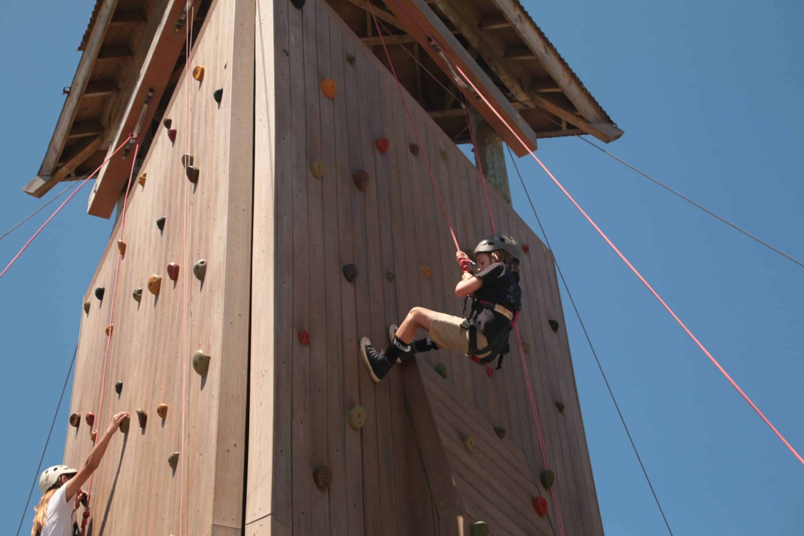 A camper climbs the camp climbing tower